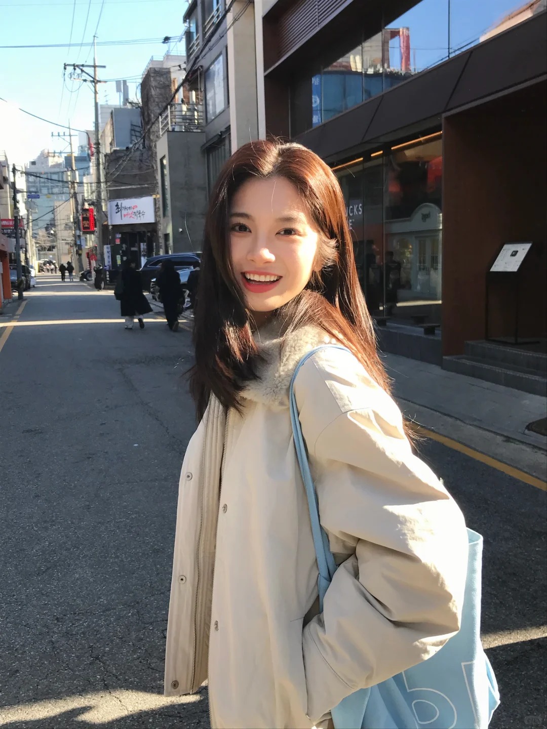 穿浅色风衣的女性在街边